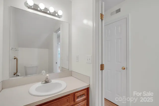 a bathroom with a sink vanity granite and a mirror