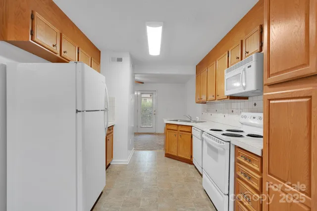 a kitchen with stainless steel appliances granite countertop a refrigerator a stove and a sink