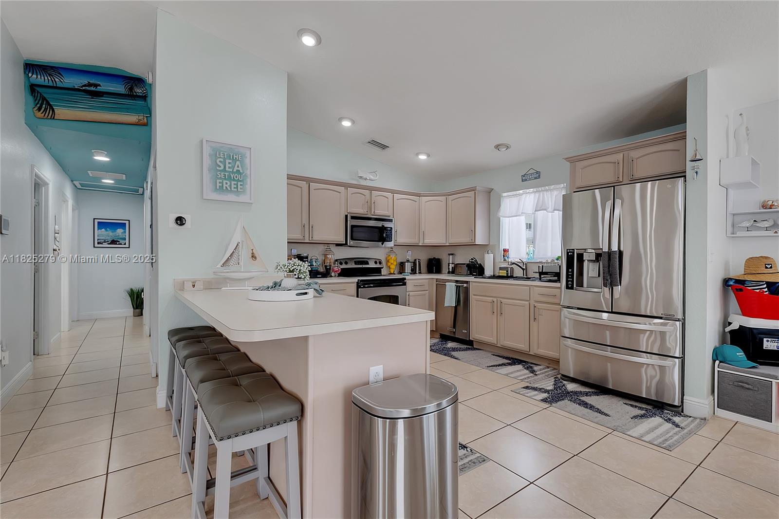 939 Plantation Road Key Largo, FL 33037 - Photo 15 of 41 a kitchen with white cabinets and stainless steel appliances
