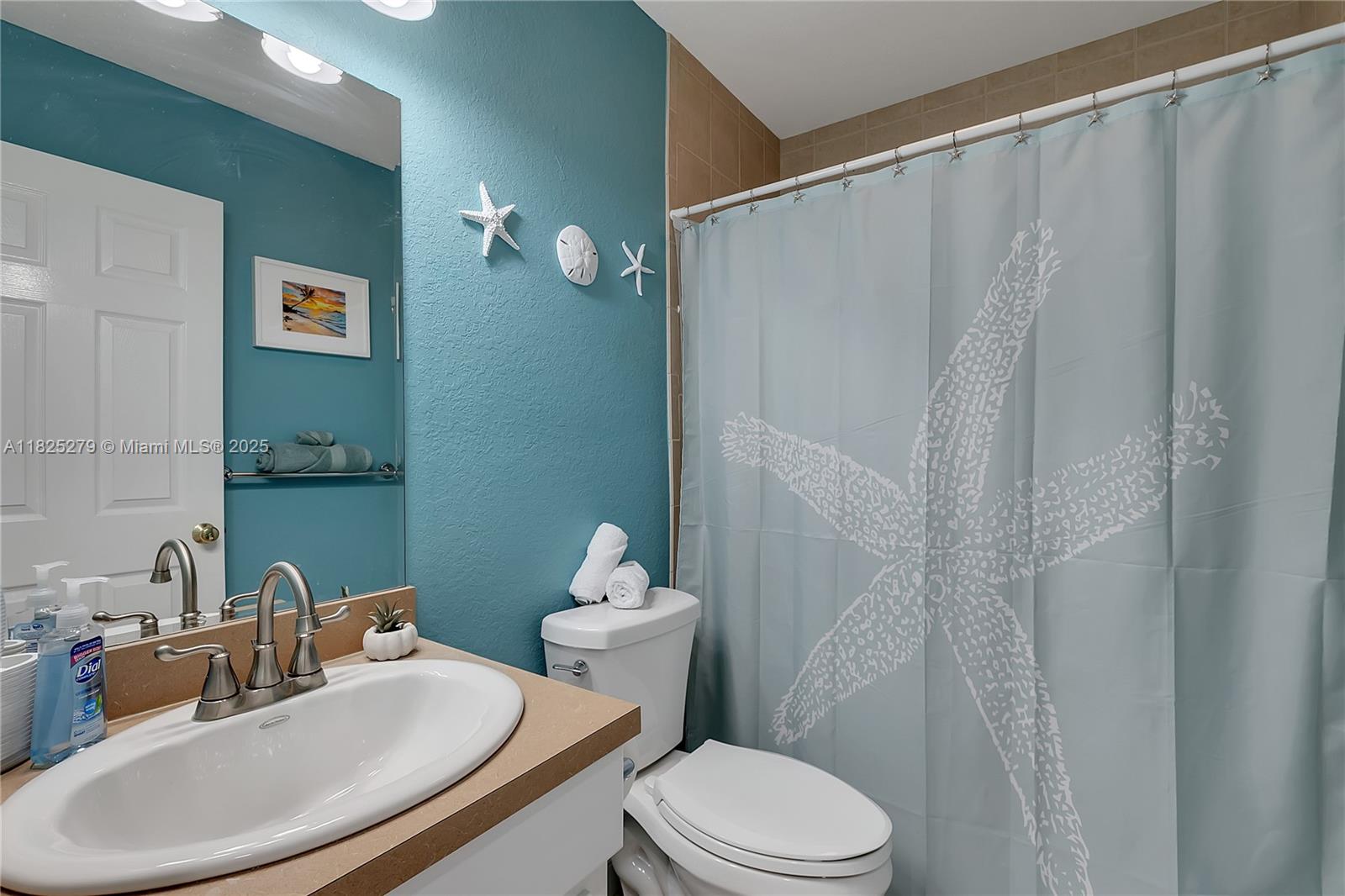 939 Plantation Road Key Largo, FL 33037 - Photo 19 of 41 a bathroom with a sink a toilet and shower curtain