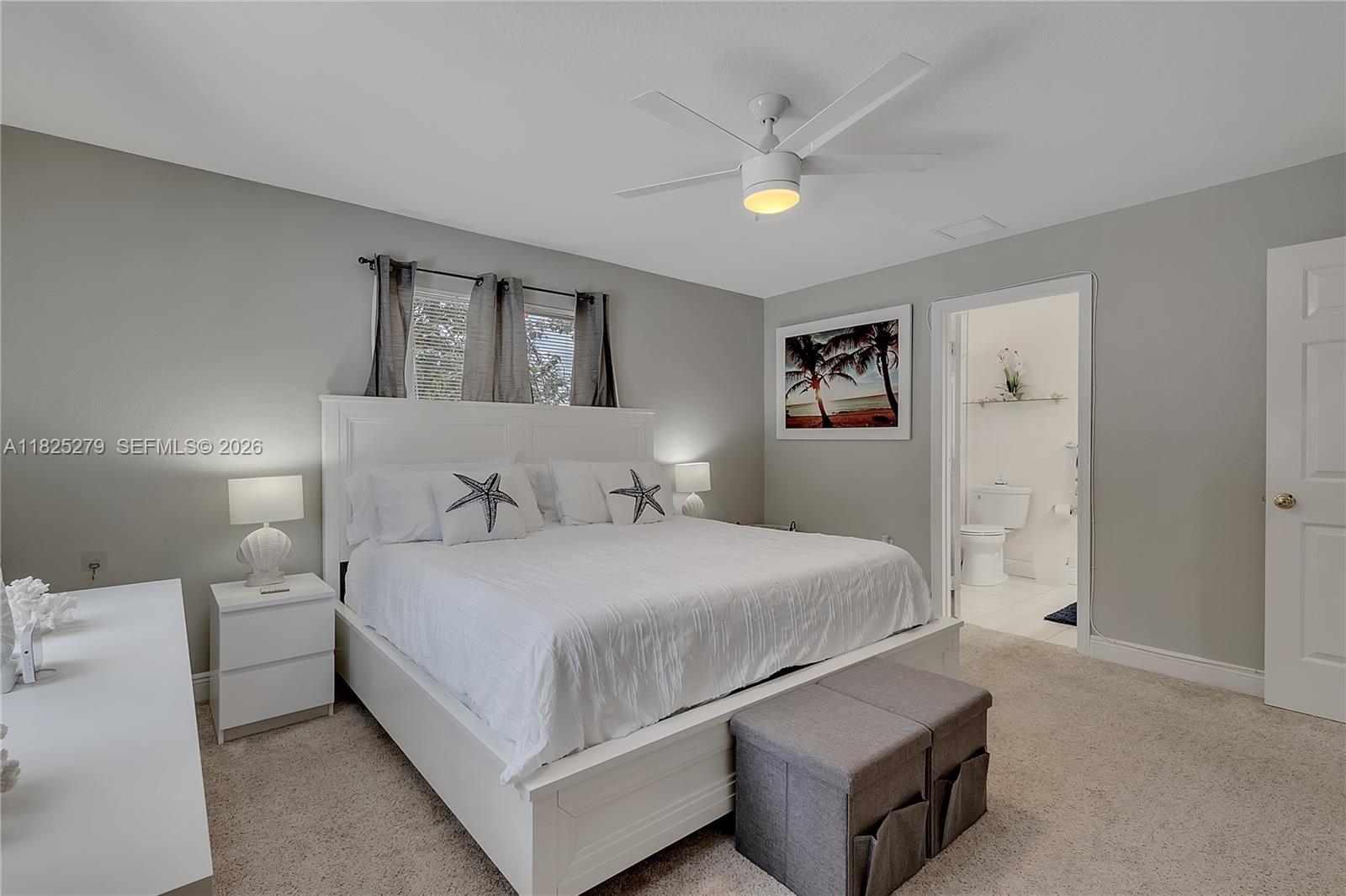 939 Plantation Road Key Largo, FL 33037 - Photo 21 of 40 a bedroom with a large bed and a chandelier