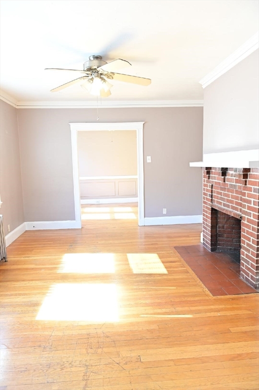 90 Elmer Road, Unit 2 Boston, MA 02124 - Photo 2 of 12 a view of a livingroom with a fireplace a ceiling fan and windows