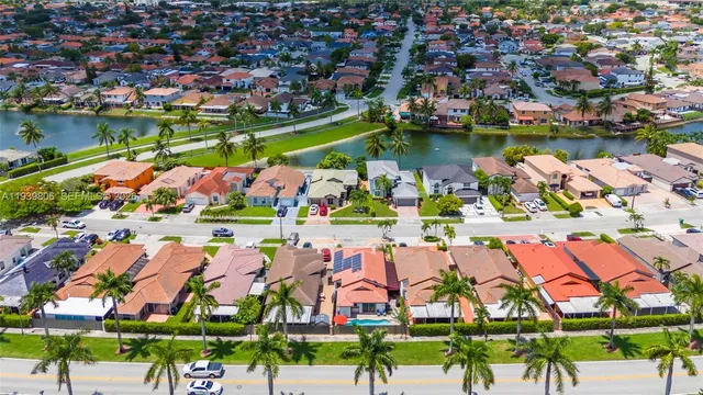 an aerial view of residential houses with outdoor space and lake view