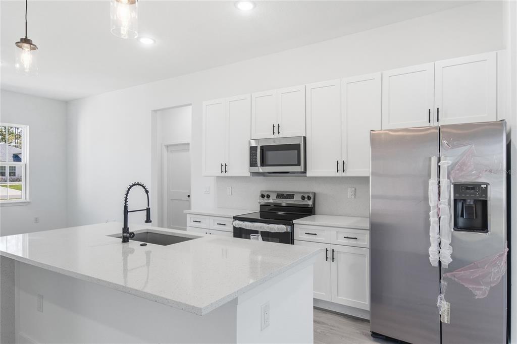 2600 Southwest 146th Pl Road Ocala, FL 34473 - Photo 3 of 40 a kitchen with stainless steel appliances a sink a microwave a refrigerator and cabinets