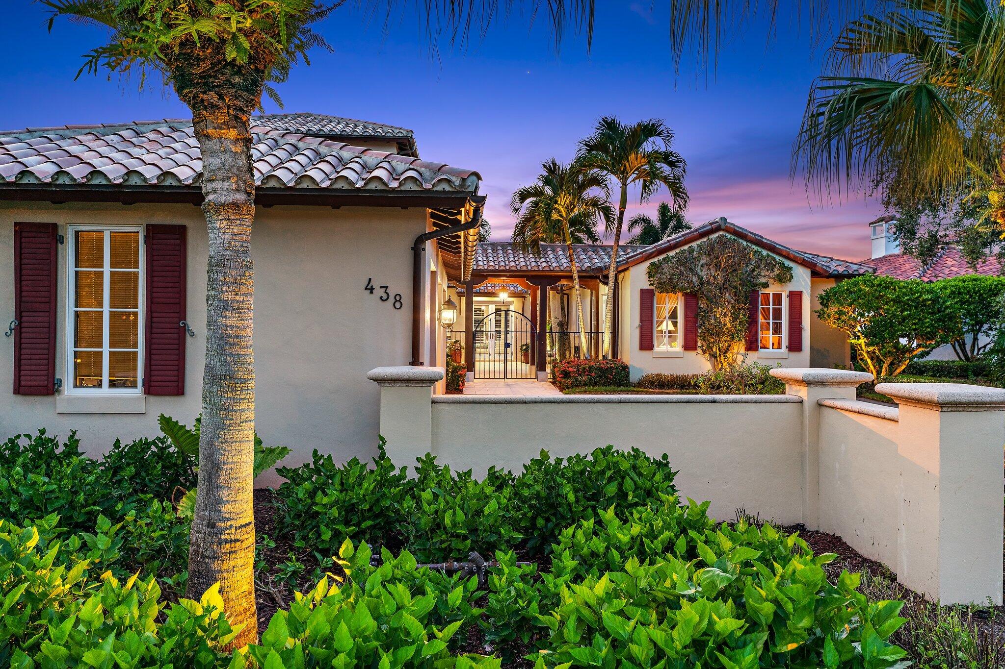 438 Red Hawk Drive Jupiter, FL 33477 - Photo 32 of 116 a front view of house and yard with beautiful flowers and green space
