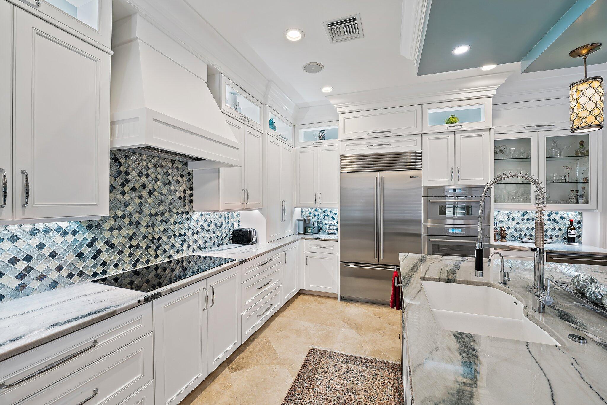 438 Red Hawk Drive Jupiter, FL 33477 - Photo 58 of 116 a kitchen with stainless steel appliances kitchen island granite countertop a refrigerator and a sink