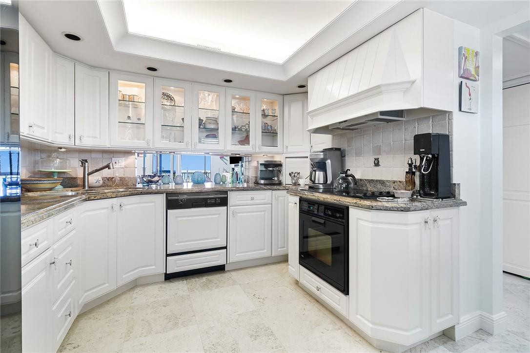 2871 North Ocean Boulevard, Unit D518 Boca Raton, FL 33431 - Photo 1 of 28 a kitchen with white cabinets and white appliances