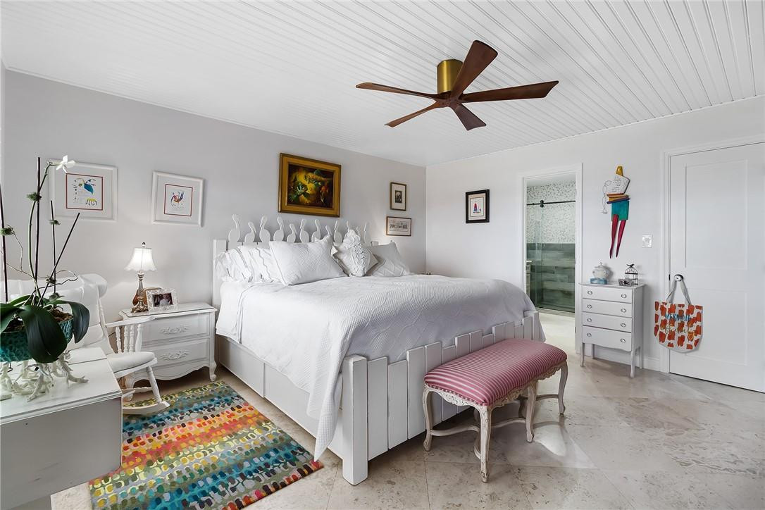 2871 North Ocean Boulevard, Unit D518 Boca Raton, FL 33431 - Photo 18 of 28 a spacious bedroom with a bed and a chandelier