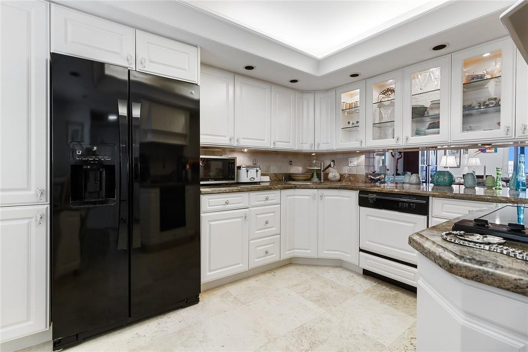 2871 North Ocean Boulevard, Unit D518 Boca Raton, FL 33431 - Photo 4 of 28 a kitchen with cabinets and stainless steel appliances