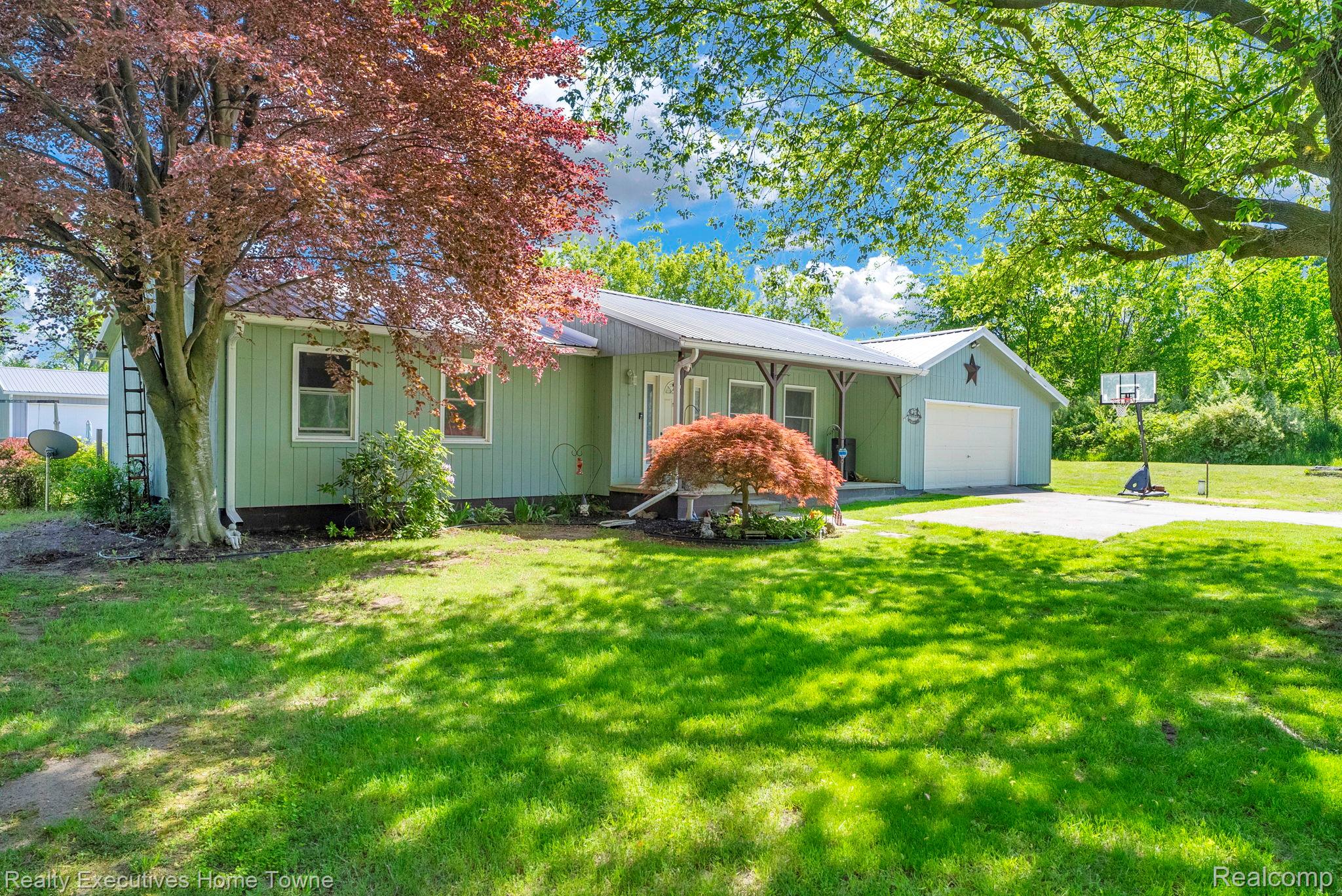 6560 Roach Road Lexington, MI 48450 - Photo 3 of 36 Ranch-style exterior with light green siding and a metal roof