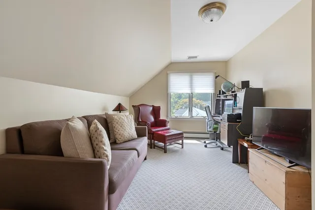 a living room with furniture a flat screen tv and a window