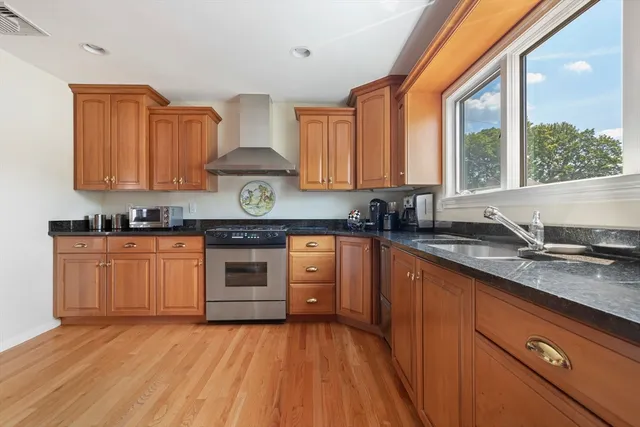 a kitchen with granite countertop wooden cabinets and a stove