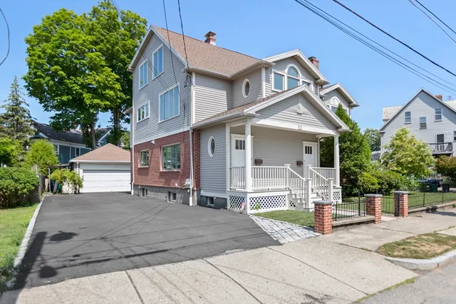 a front view of a house with a garden and plants