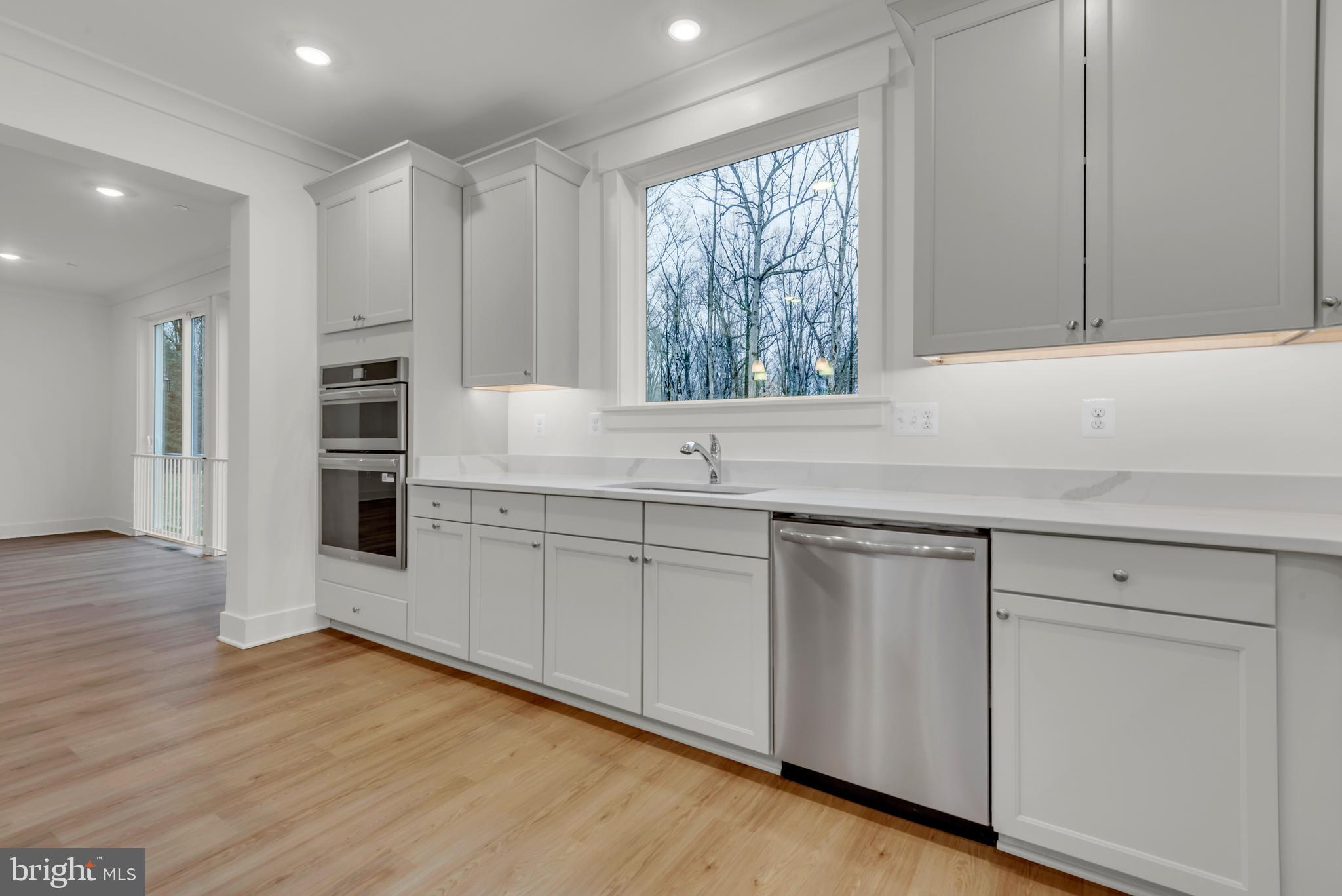 6502 Whitetail Xing Way Hanover, MD 21076 - Photo 12 of 58 a kitchen with stainless steel appliances granite countertop a sink and cabinets with wooden floor