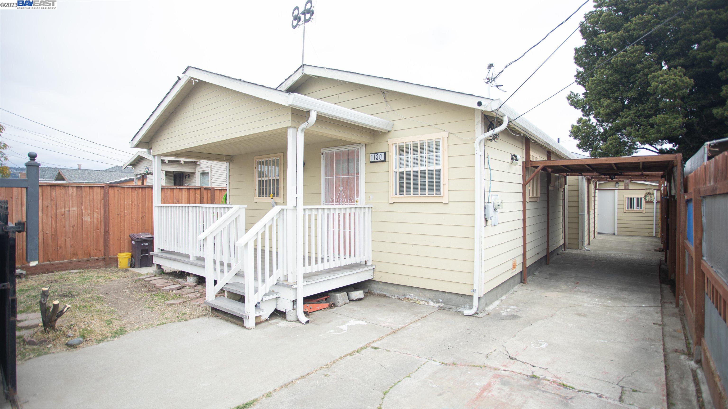 a view of a house with a yard and wooden fence