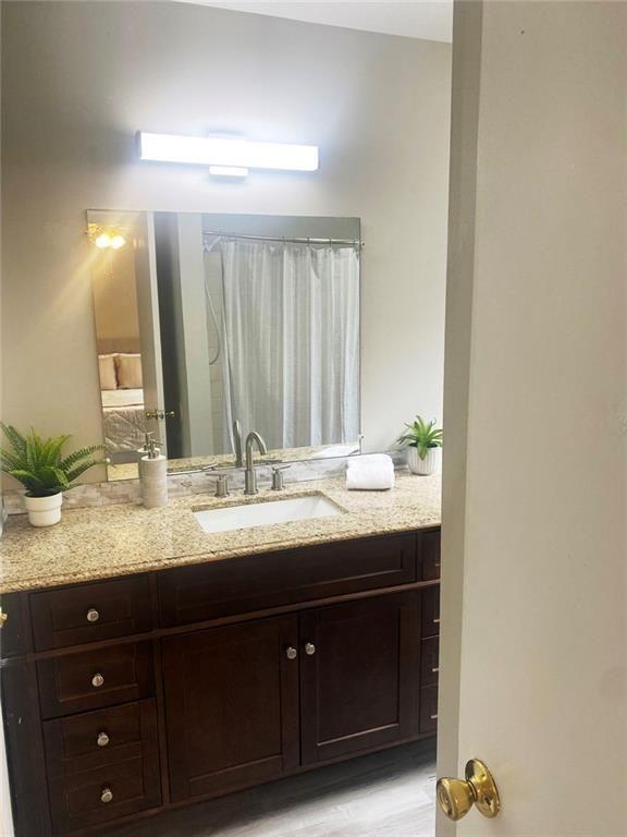 4701 Flat Shoals Road, Unit 5D Union City, GA 30291 - Photo 15 of 20 a bathroom with a granite countertop sink and a mirror