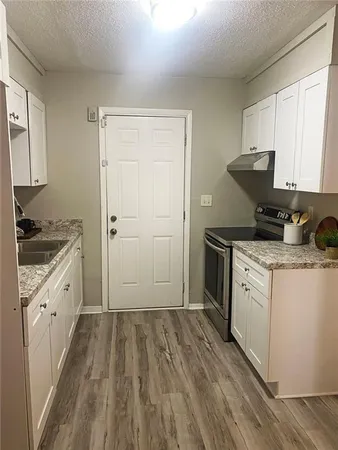a kitchen with a sink stove and cabinets
