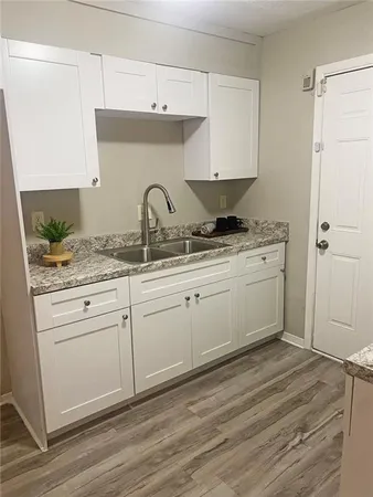 a kitchen with stainless steel appliances granite countertop a sink a stove and white cabinets