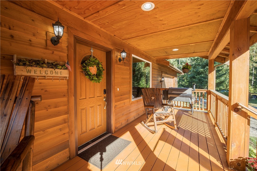 204 Webb Road Southwest Lakebay, WA 98349 - Photo 4 of 31 a view of a balcony with chairs and wooden floor