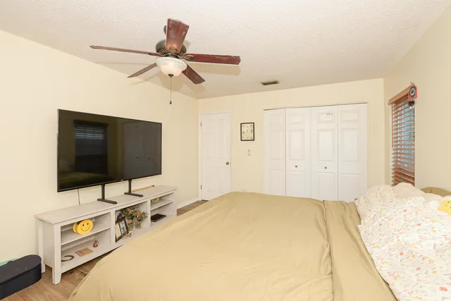 a bedroom with a bed and a flat screen tv