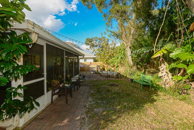 a backyard of a house with table and chairs