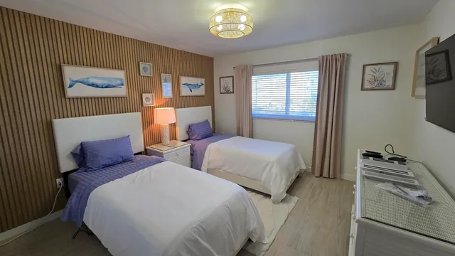 a bedroom with two beds and a chandelier