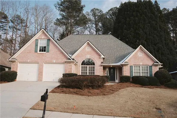a front view of a house with a yard and trees