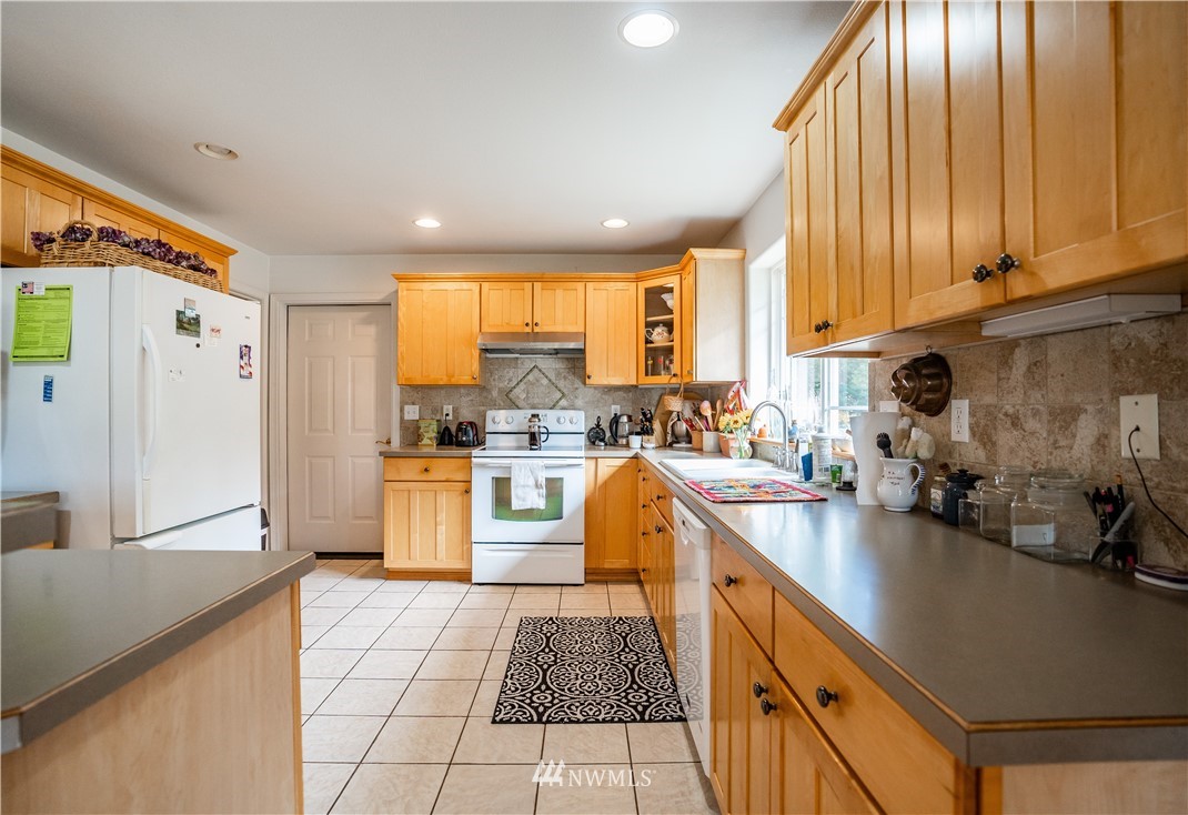 18806 Sams Place Southwest Rochester, WA 98579 - Photo 16 of 40 a kitchen with a sink appliances cabinets and a counter top space