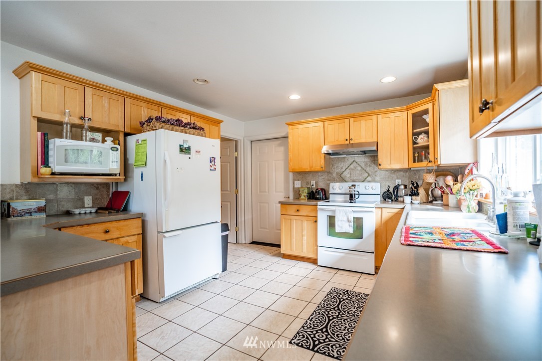 18806 Sams Place Southwest Rochester, WA 98579 - Photo 17 of 40 a kitchen with stainless steel appliances granite countertop a refrigerator stove top oven and sink
