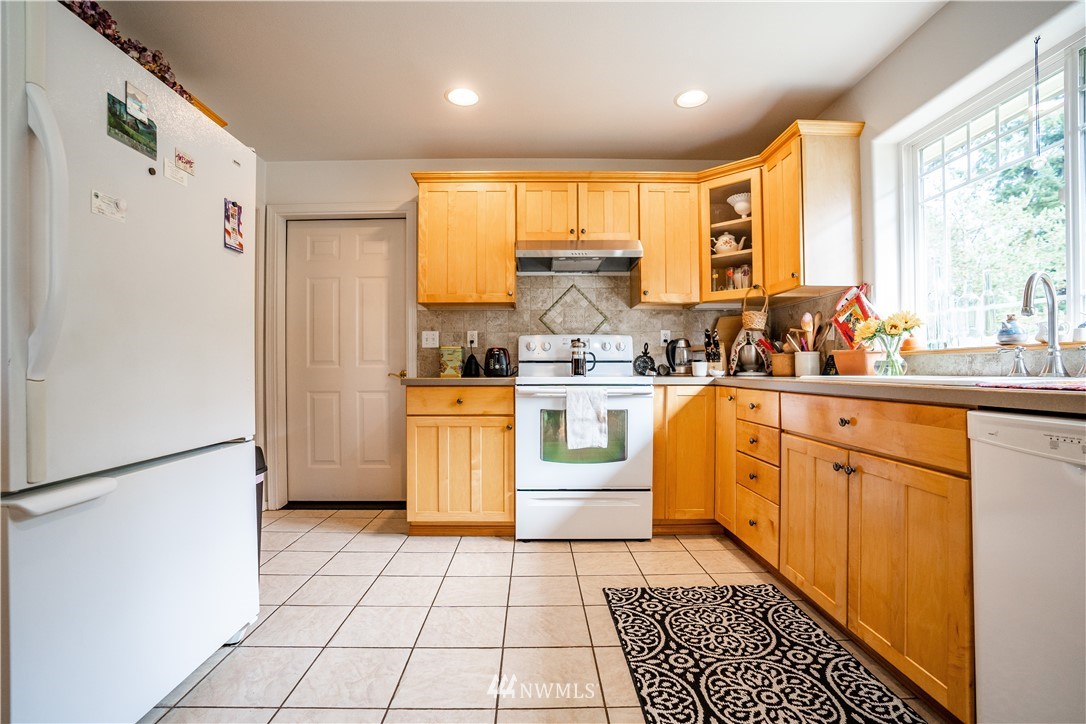 18806 Sams Place Southwest Rochester, WA 98579 - Photo 18 of 40 a kitchen with sink a refrigerator and cabinets