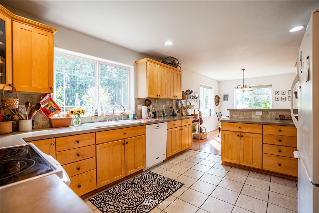 18806 Sams Place Southwest Rochester, WA 98579 - Photo 21 of 40 a large kitchen with kitchen island granite countertop a large window in it