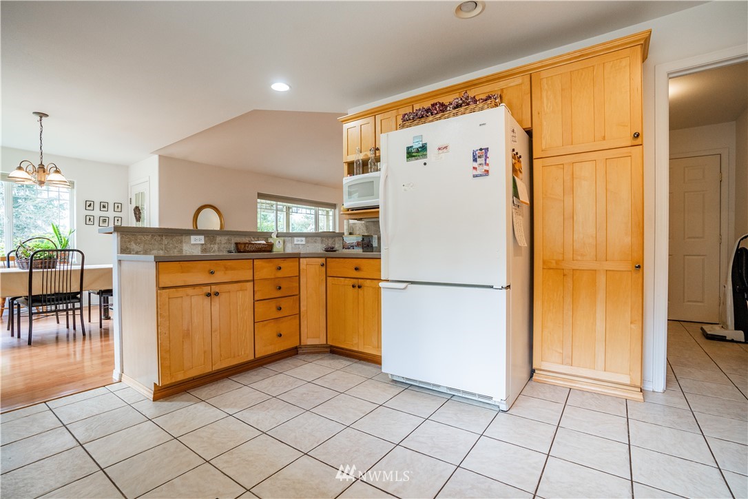 18806 Sams Place Southwest Rochester, WA 98579 - Photo 22 of 40 a white refrigerator freezer sitting in a kitchen with white cabinets