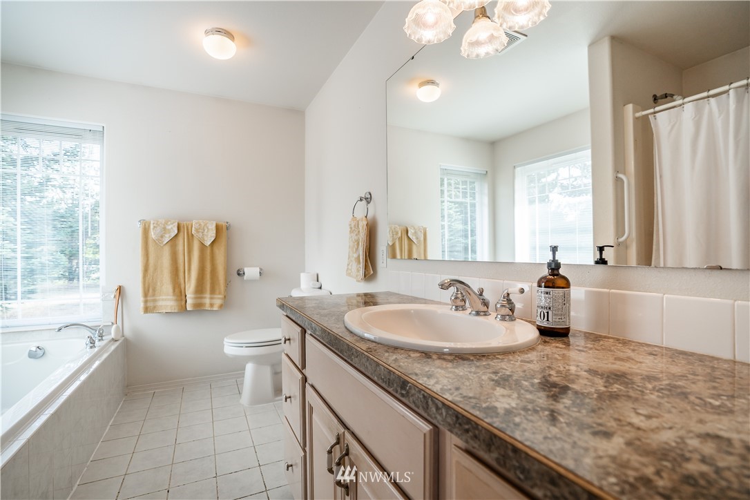 18806 Sams Place Southwest Rochester, WA 98579 - Photo 30 of 40 a bathroom with a granite countertop sink and a bathtub