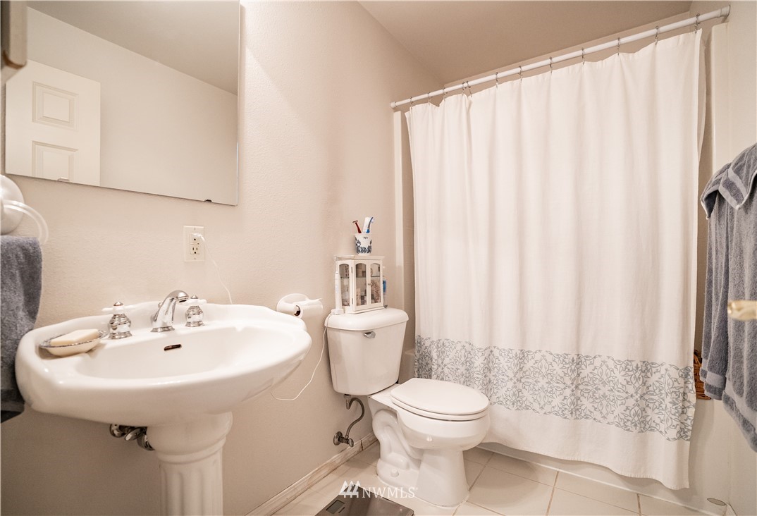 18806 Sams Place Southwest Rochester, WA 98579 - Photo 34 of 40 a bathroom with a sink a toilet and shower curtain