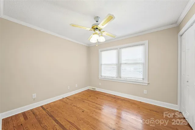 an empty room with a window and a ceiling fan