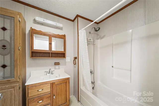 a bathroom with a granite countertop sink a mirror a bathtub and shower