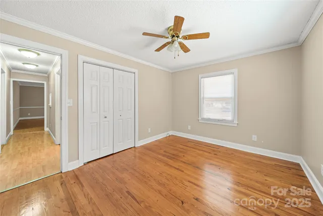 a view of a room with wooden floor and a ceiling fan