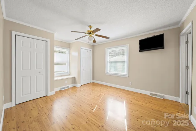 a view of empty room with window and ceiling fan