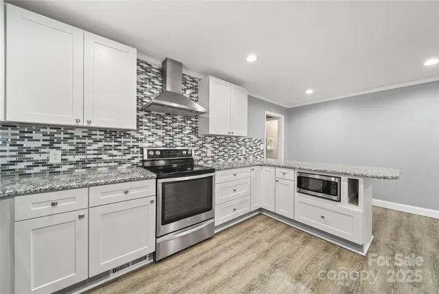 a kitchen with stainless steel appliances granite countertop a stove a sink and a microwave