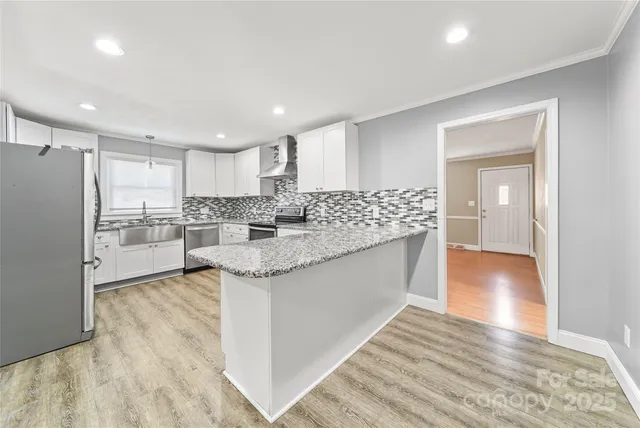 a kitchen with stainless steel appliances granite countertop a sink and a refrigerator