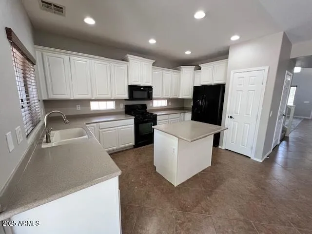 a kitchen with a sink a microwave a refrigerator and cabinets