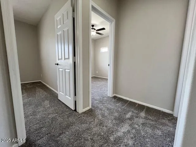 an empty room with fan closet and windows