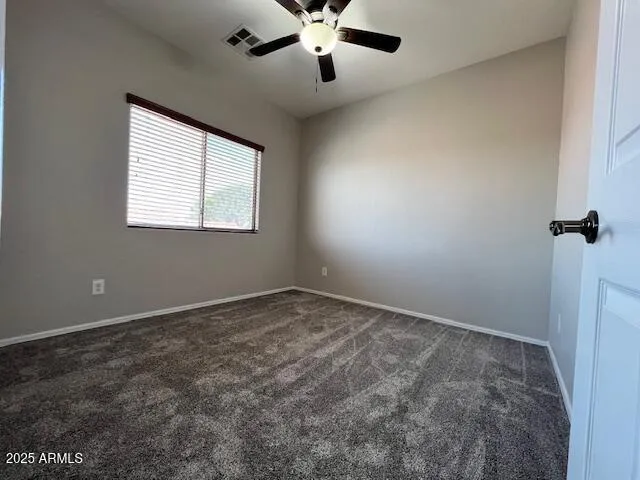 an empty room with a window and a fan