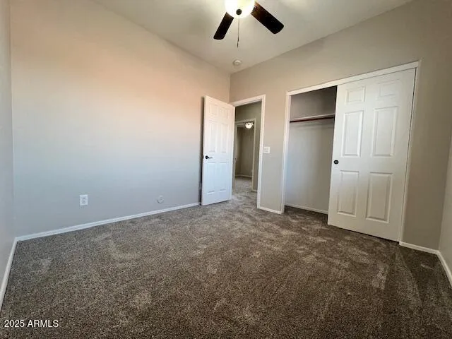 an empty room with a ceiling fan and entryway