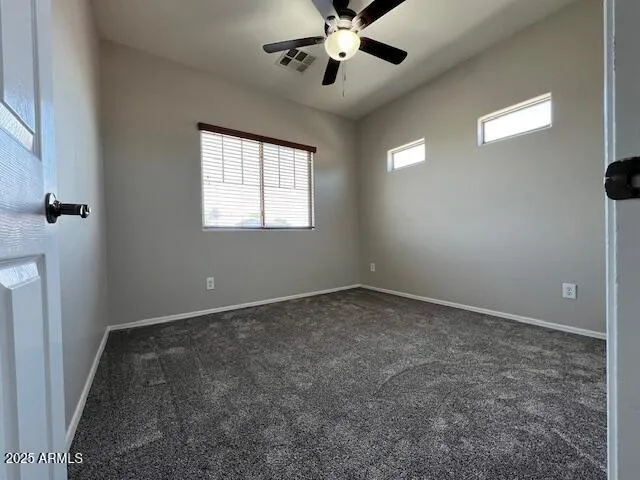 an empty room with a window and a ceiling fan