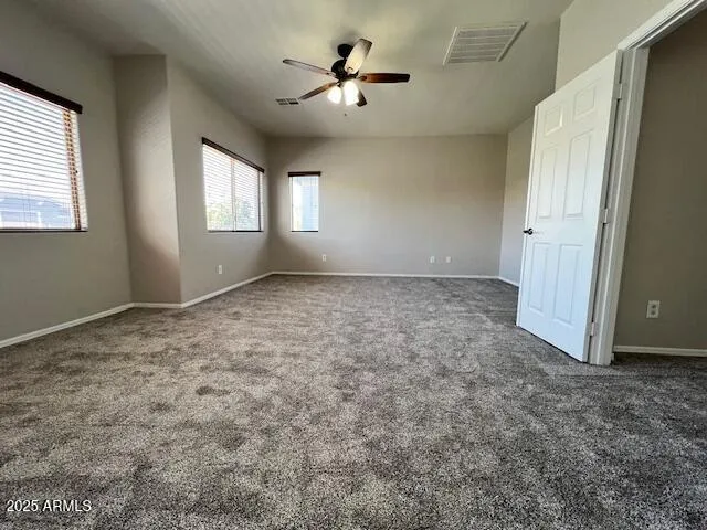 an empty room with closet and windows
