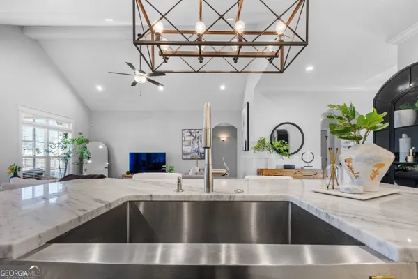 a living room with furniture a chandelier and a flat screen tv