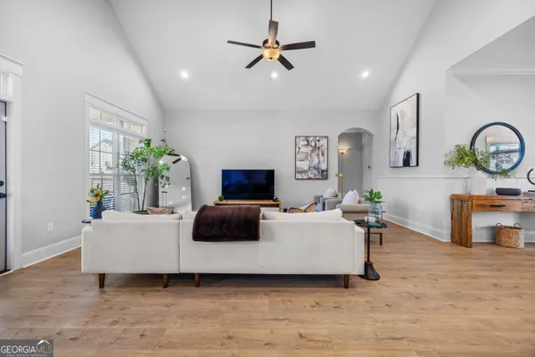 a bedroom with a bed a couch and a flat screen tv