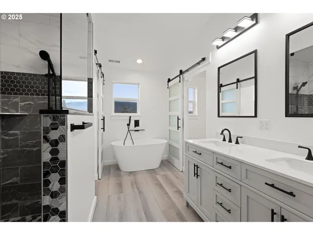 a bathroom with double vanity sink and two mirror