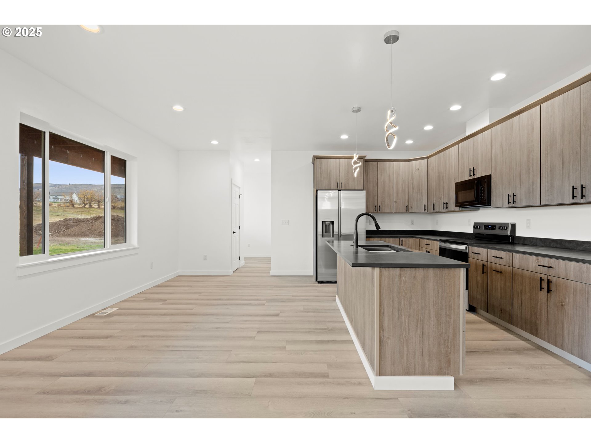 240 Heritage Lane Union, OR 97883 - Photo 10 of 36 a kitchen with stainless steel appliances granite countertop a stove a sink a refrigerator and white cabinets with wooden floor